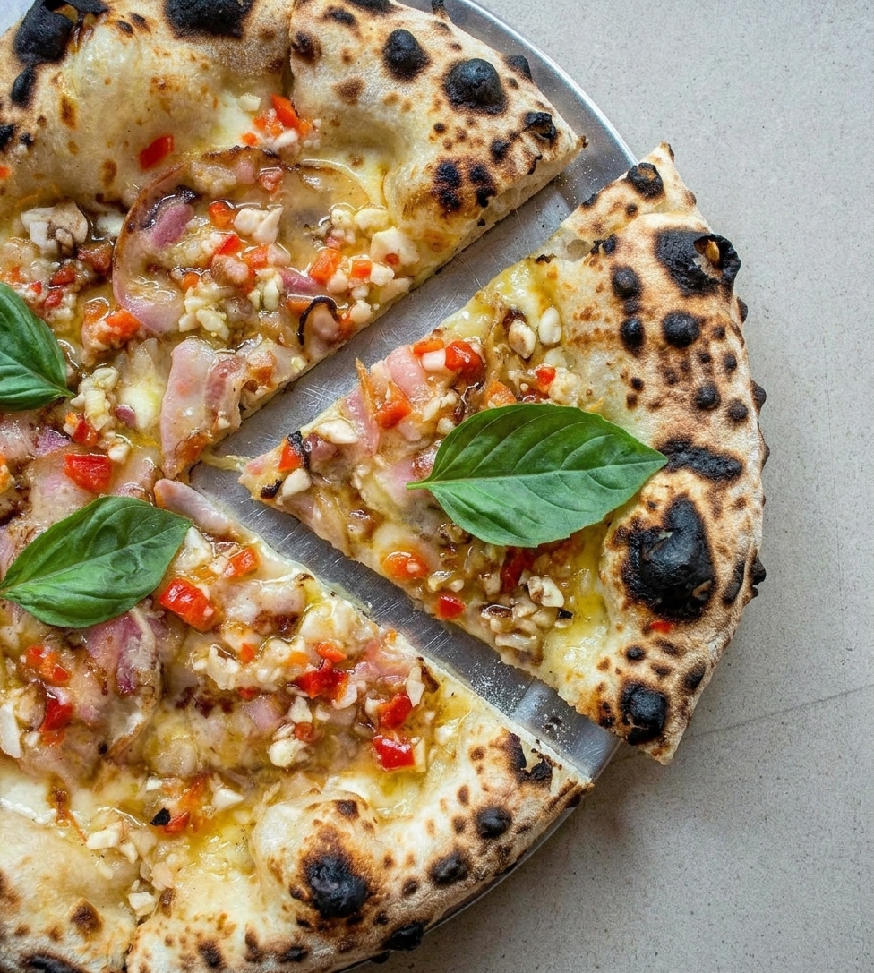 Pizza napolitana Pancetozzi com molho de tomate amarelo, pancetta fumada, grana padano e manjericão, saída do forno da Tozzi Forneria Moderna em Lisboa