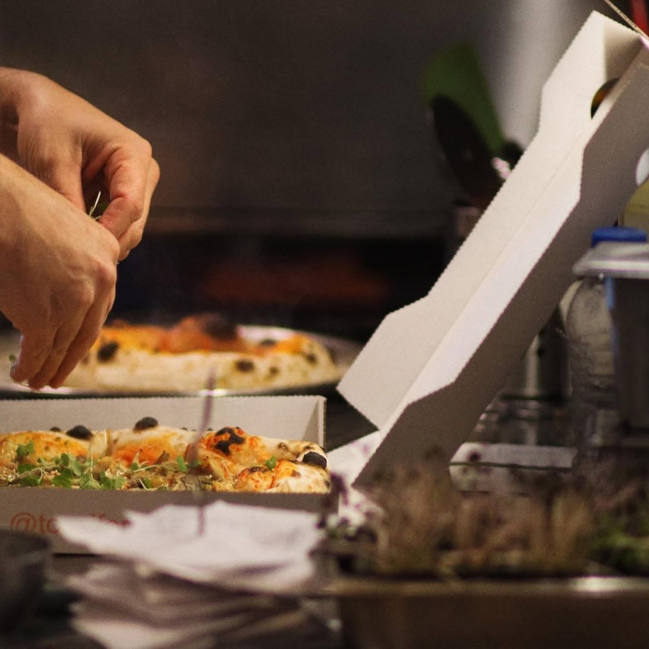 Pizzaiolo a finalizar uma pizza napolitana junto ao forno da Tozzi Forneria Moderna, Rua Latino Coelho, Lisboa