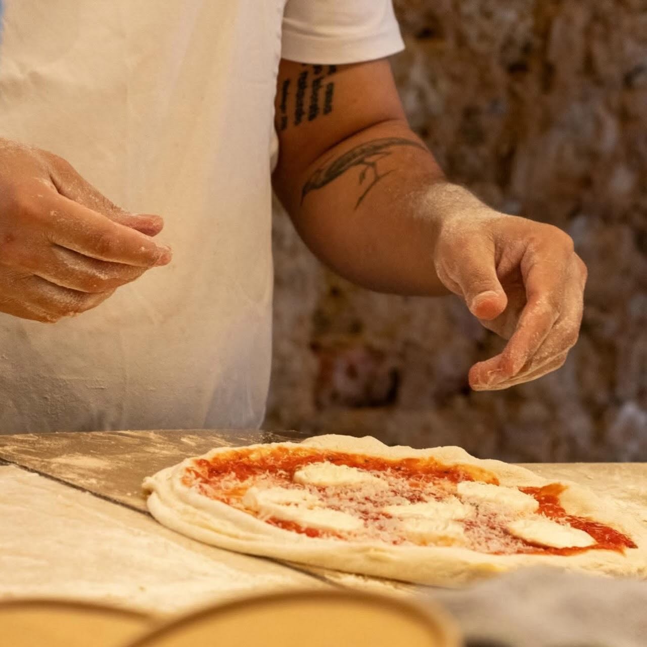 Pizzaiolo da Tozzi Forneria Moderna a preparar massa de pizza napolitana com molho de tomate e mozzarella, Lisboa